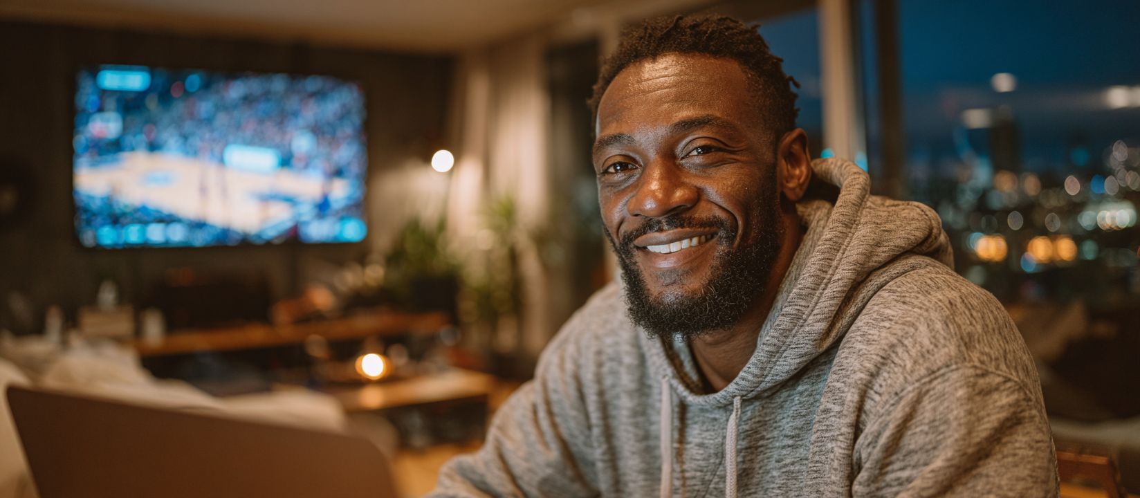 Cheerful man watching live basketball and betting online with OKBAJE sports
